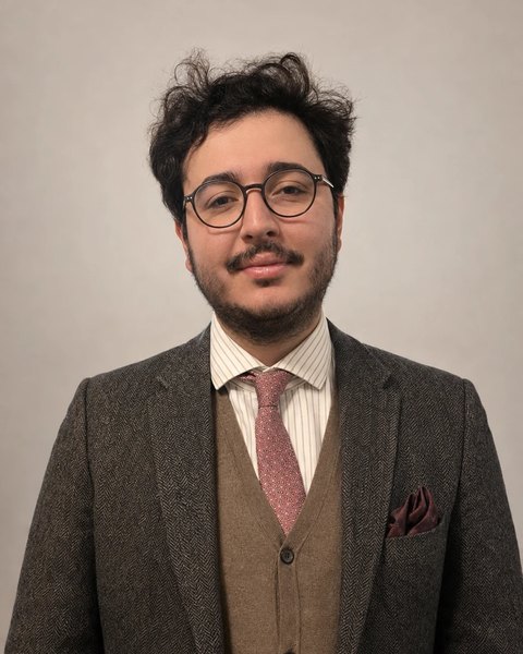 Ahmed Zeyd Aytac in Tweedsakko und Weste vor hellem Hintergrund
